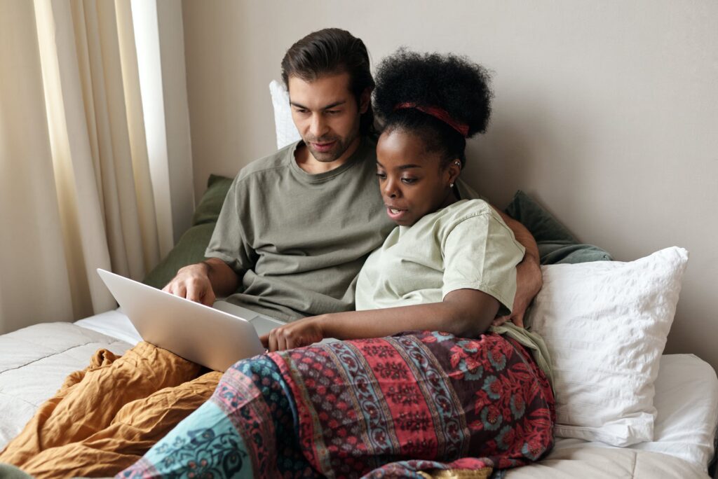 couple with a laptop in bed